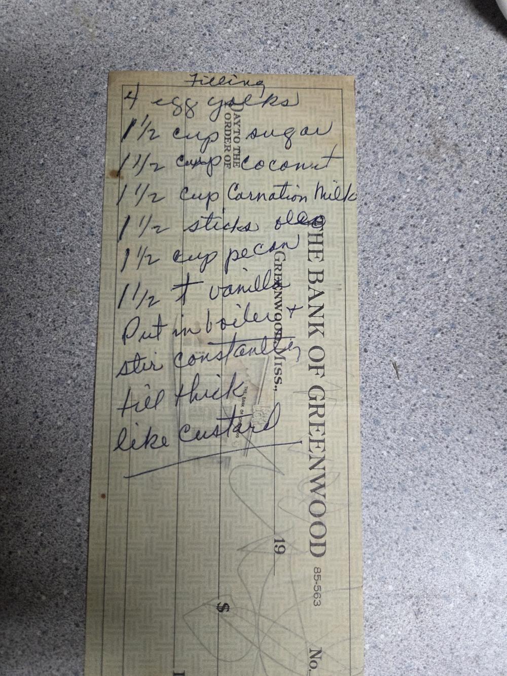The filling for her German chocolate cake — coconut, pecans, and Carnation milk — written right across a bank check